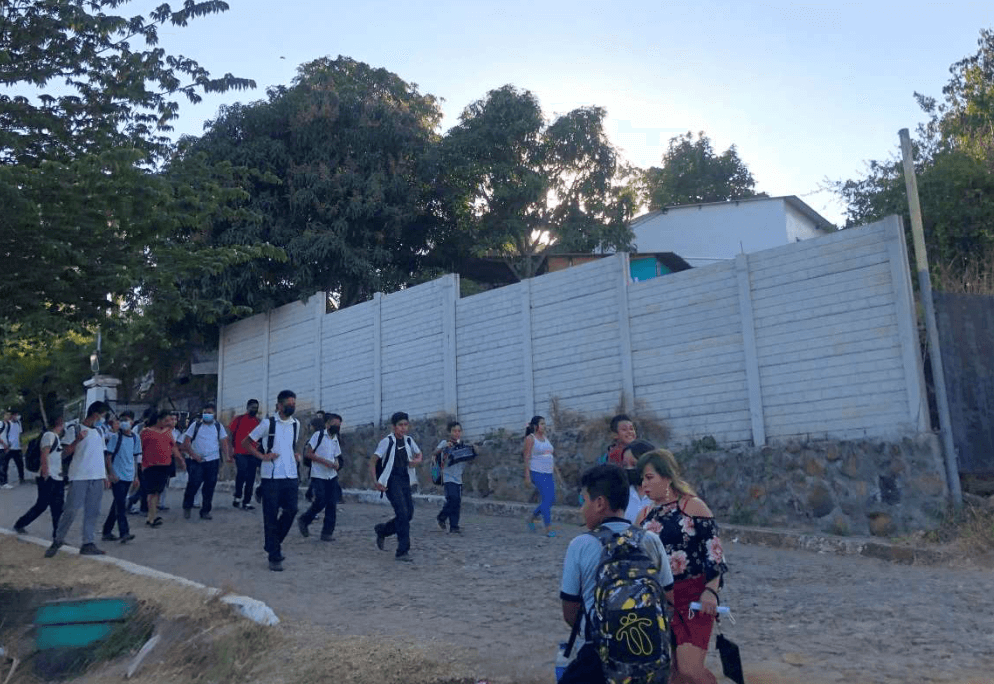 Students walking in front of perimeter wall
