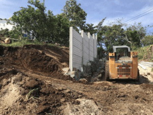 bulldozer excavating around a wall