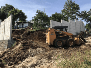 bulldozer excavating around a wall